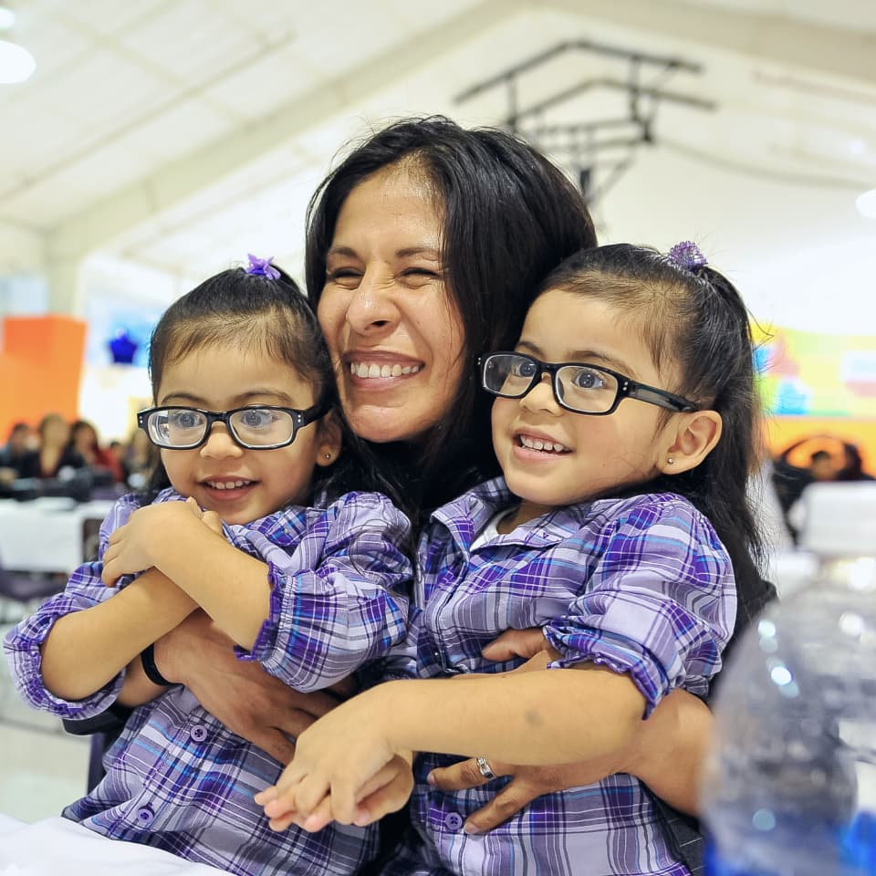 Woman holding twin daughters